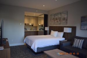 High Point Resort في Quathiaski Cove: غرفة نوم بسرير كبير وأريكة