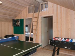 a room with a ping pong table and a bunk bed at 12 person holiday home in R m in Bolilmark