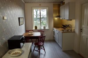 a kitchen with a table and chairs and a window at Hidingsta gård B&B in Örebro