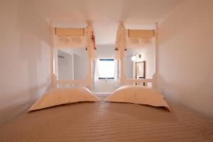 1 dormitorio con 2 camas y ventana en Maria's Anatolia Villa, en Karpathos