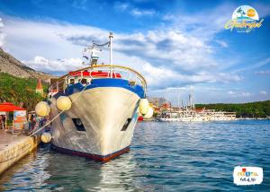 a boat is docked at a dock in the water at Gabrijel Apartments Makarska 1 in Makarska