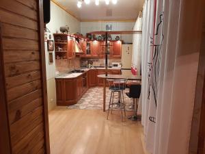 a kitchen with wooden cabinets and a table in it at Куренiвський Двiр in Kyiv +26 photos