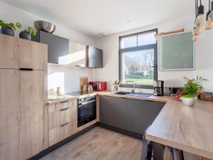 a kitchen with wooden cabinets and a large window at Vintage Holiday Home in Escalles with Garden in Escalles
