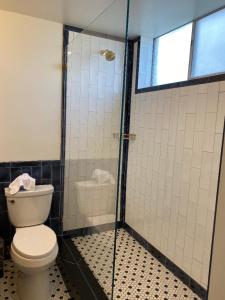 a bathroom with a toilet, sink, and shower at The Adler a Hollywood Hotel in Los Angeles