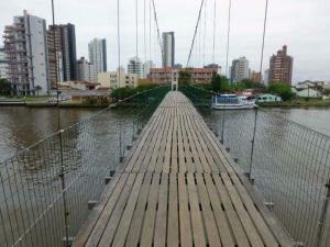 uma ponte sobre um rio com uma cidade ao fundo em Casa de praia em Passo de Torres