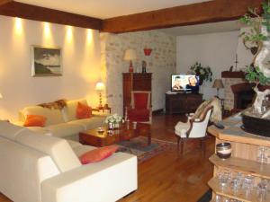 a living room with a white couch and a table at Les Ecureuils in Bougligny