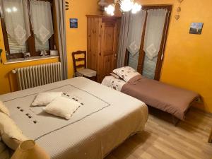 2 camas en una habitación con paredes amarillas en Chambres d'Hôtes des Cascades St-Nicolas en Kruth