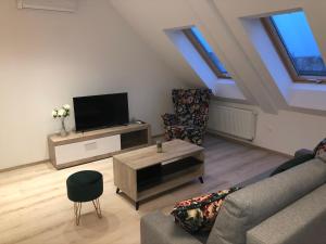 uma sala de estar com uma televisão de ecrã plano e um sofá em Diamond Apartman em Debrecen