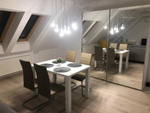 uma sala de jantar com uma mesa branca e cadeiras em Diamond Apartman em Debrecen