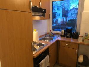 呂貝克的住宿－Super Lage, neu renovierte, gemütliche Unterkunft，一个带水槽和窗户的小厨房