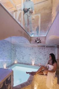 a woman sitting in a bath tub with a man taking a picture at LUX LUCIS in Matera