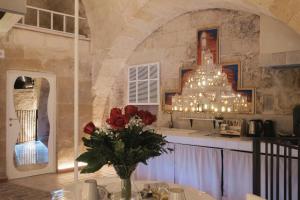 a room with a table with a vase of flowers at LUX LUCIS in Matera
