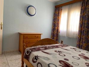 a bedroom with a bed and a dresser and a mirror at El Beril in Adeje