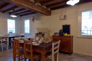 Antico Podere Emilia في ريجيو إيميليا: غرفة طعام مع طاولة وكراسي خشبية