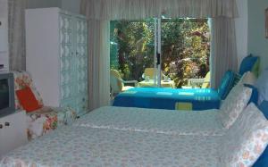 sypialnia z 2 łóżkami i dużym oknem w obiekcie Rachel's Home From Home w Kapsztadzie