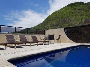 a group of chairs sitting next to a swimming pool at Majestic Rio Palace Hotel in Rio de Janeiro