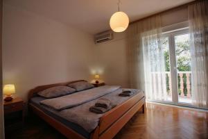 ein Schlafzimmer mit einem Bett und einem großen Fenster in der Unterkunft House Barbara in Novi Vinodolski