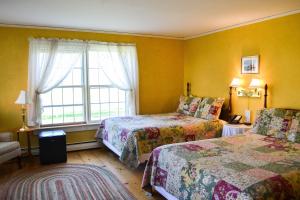 um quarto de hotel com duas camas e uma janela em The Quechee Inn at Marshland Farm em Quechee