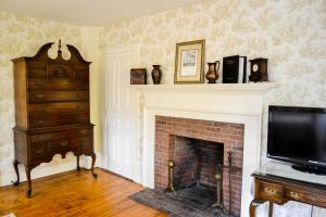 Una sala de estar con chimenea y televisión. en The Quechee Inn at Marshland Farm, en Quechee
