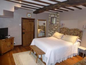 a bedroom with a large bed and a television at Badgers Hall in Chipping Campden