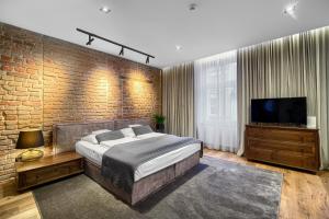 海烏姆諾的住宿－克爾明斯基公寓，一间卧室设有一张大床和砖墙