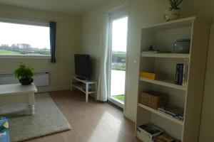 un soggiorno con TV e finestra di Water & Meadow cottage in Central Holland 2A & 2C a Schoonrewoerd