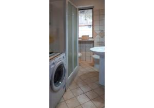 ein Badezimmer mit Waschmaschine und Waschbecken in der Unterkunft La Casa di Anna in Castellabate + 6 Fotos