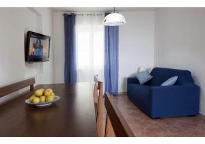 ein Wohnzimmer mit einem Tisch und einem blauen Stuhl in der Unterkunft La Casa di Anna in Castellabate