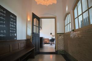 a hallway with a door and a chalkboard on the wall at Overnachten in de oude West-Indiëschool in Enschede