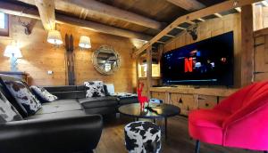 sala de estar con sofá y TV en Cosy Lodge au pied de l'Alpe D'Huez SKi et Détente Jacuzzi Piscine Sauna Bar Billard, en Le Bourg-dʼOisans