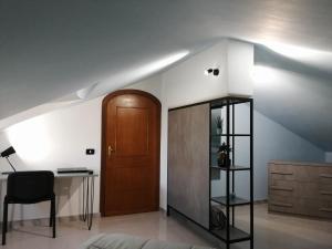 Habitación con puerta, escritorio y silla en Kalispéra B&B en Guidonia
