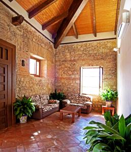 una sala de estar con sofás y una pared de piedra. en Hotel Rural El Salero, en Torija