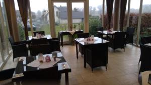 um restaurante com mesas e cadeiras numa sala com janelas em Gästehaus Chalet Ochtrup em Ochtrup