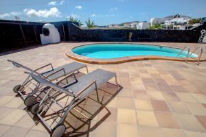 a couple of chairs and a swimming pool at casa los veroles lanzarote in El Islote