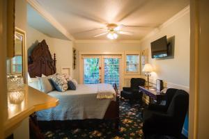 a bedroom with a bed and a desk and two chairs at The Campbell House Inn in Eugene