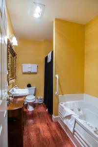 The Campbell House Inn في يوجين: حمام مع حوض ومرحاض ومغسلة