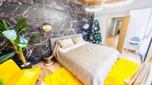a bedroom with a bed and a christmas tree in it at Maya Luxury Residence in Poiana Brasov
