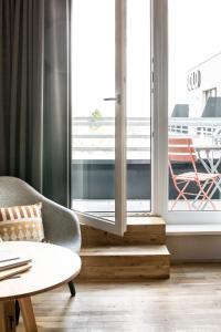 a living room with a chair and a table at Bold Hotel München Giesing in Munich