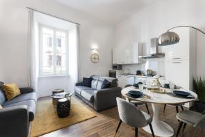 a white living room with a table and a kitchen at Lovely Rome Apartments in Rome