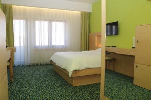 a hotel room with a bed and a television at Hotel International Prishtina & Spa in Pristina