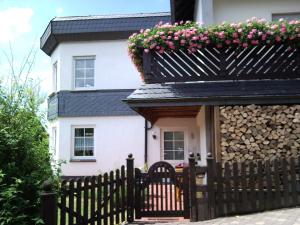 ein Haus mit einem Zaun mit einem Blumenkasten darauf in der Unterkunft Ferienwohnungen Luge - Winterberg in Winterberg