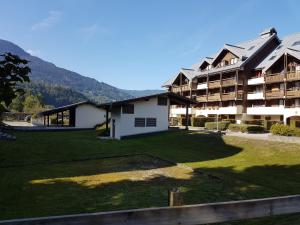 a large apartment building with a lawn in front of it at Le Duplex Septimontain in Samoëns