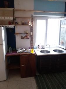 a kitchen with two sinks and a window at At Home Hostel in Korçë +25 photos