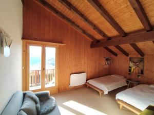 a room with two beds and a couch and a window at Chalet Bissetrot in Crans-Montana