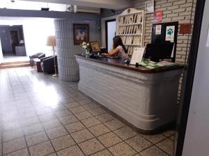 a woman sitting at the counter of a restaurant at Hotel Garden in San Miguel de Tucumán