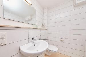 a white bathroom with a sink and a toilet at Ferienwohnung Bella Vista Premium Appartement in Bernkastel-Kues