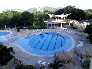 una piscina en un complejo con sillas y un edificio en SANTA MARTA OASIS en ZAZUE, en Santa Marta