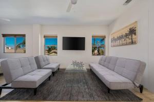 a living room with two couches and a flat screen tv at The Playa in Indio