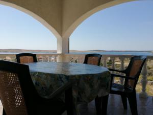 una mesa y sillas en un balcón con vistas al océano en Apartments Kuss, en Novalja