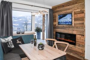 a dining room with a table and a fireplace at Alpendorf Auszeit in Sankt Johann im Pongau